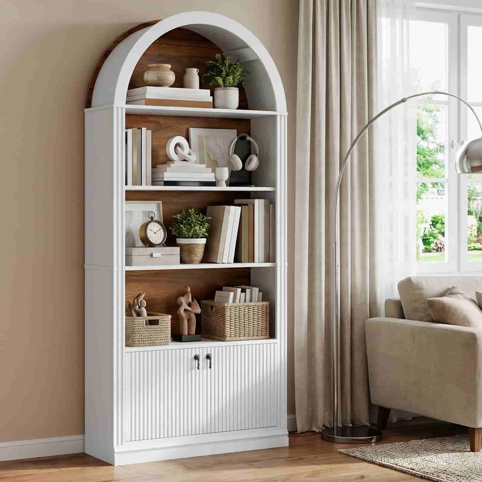 Elegant white arched bookshelf with a rustic brown wood back panel styled with books and decor in a living room.