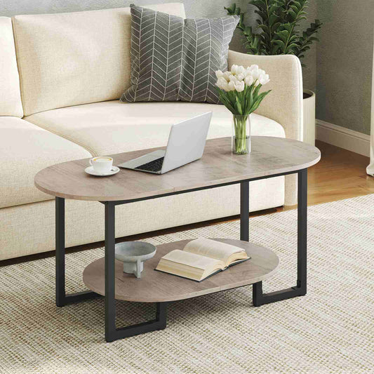 Oval coffee table being used as a laptop desk while placed next to a comfortable cream sofa.