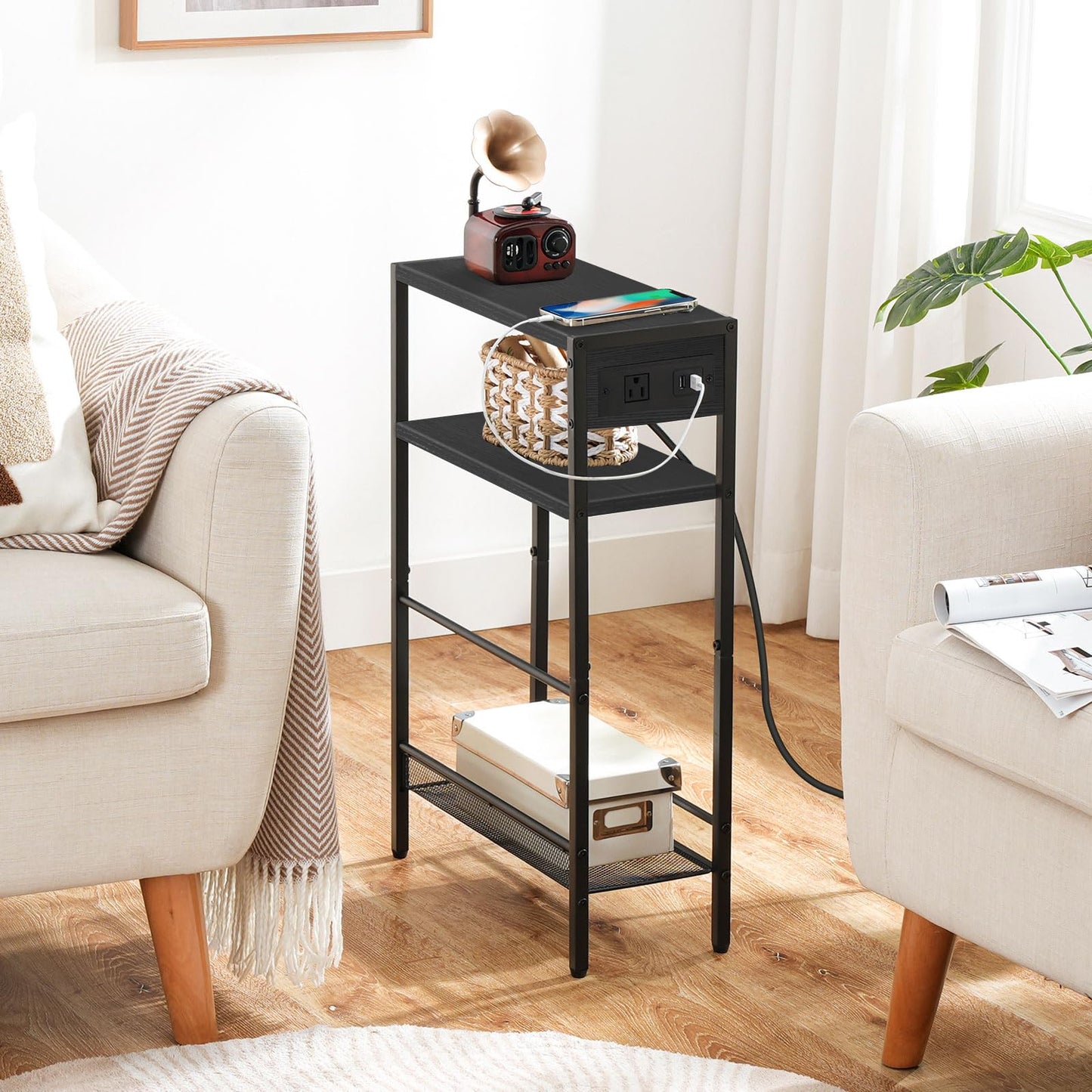 Narrow black sofa side table fitted perfectly inside a tight gap between two modern cream armchairs.