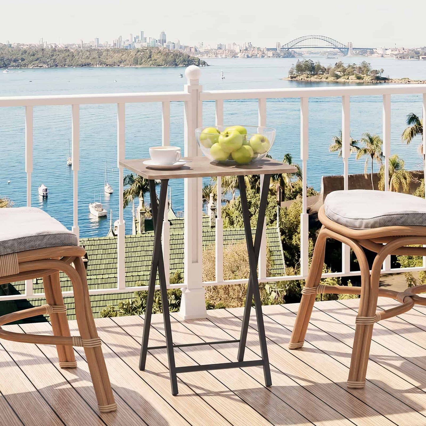 Weather-resistant portable outdoor bistro table holding drinks on a sunny balcony with a scenic water view.