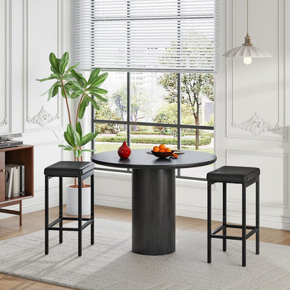 Black pub height dining stools paired with a modern round kitchen table for small spaces.
