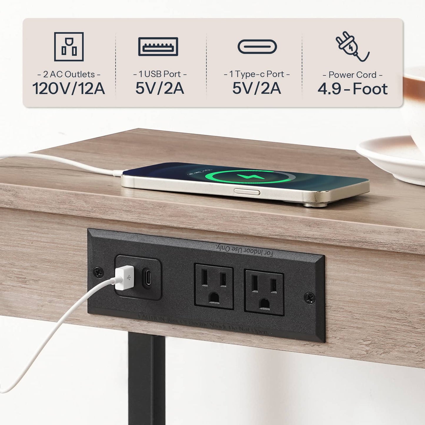 Close-up view of the recessed black power strip featuring 2 AC outlets and 2 USB ports charging a phone.