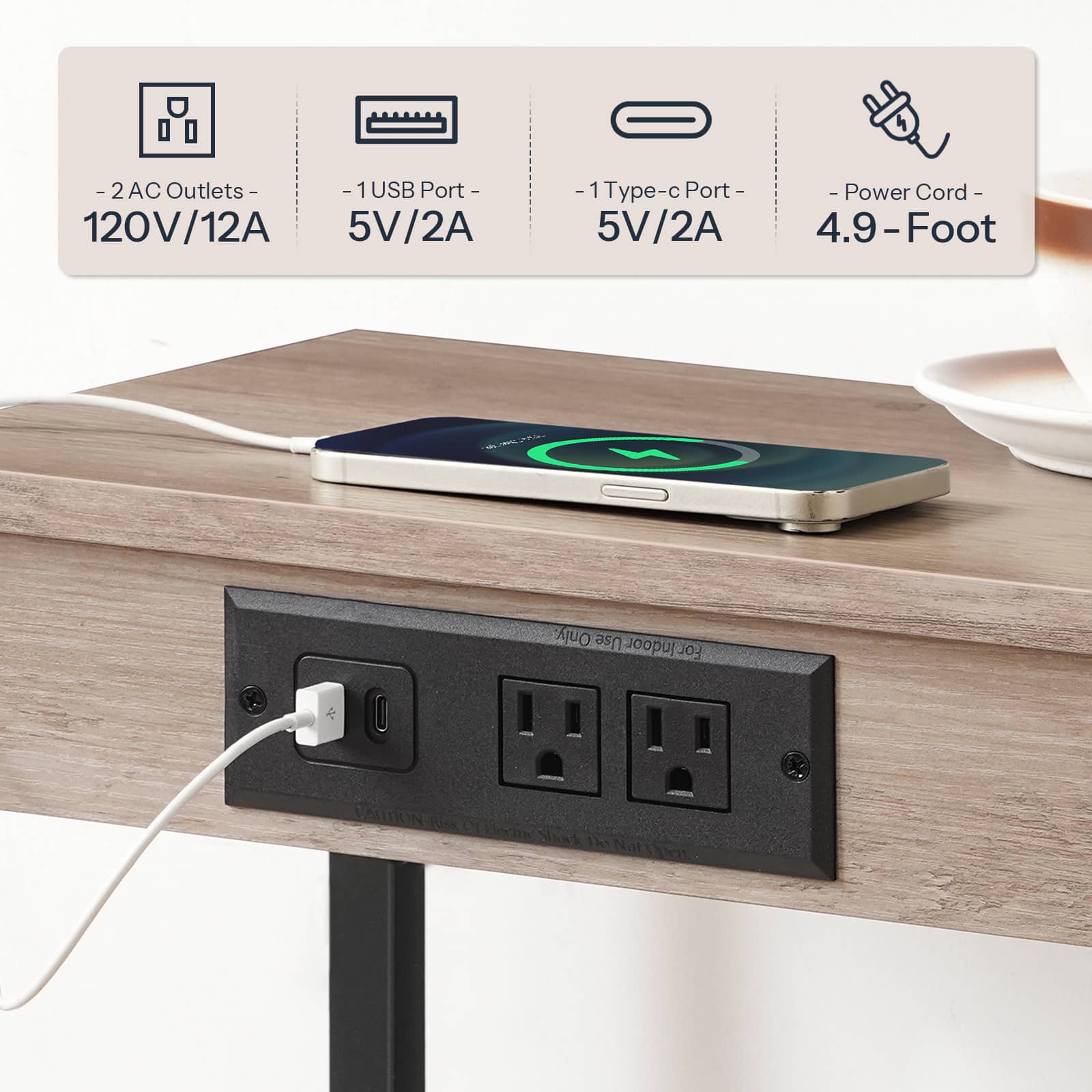 Close-up view of the recessed black power strip featuring 2 AC outlets and 2 USB ports charging a phone.