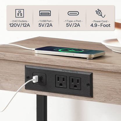 Close-up view of the recessed black power strip featuring 2 AC outlets and 2 USB ports charging a phone.