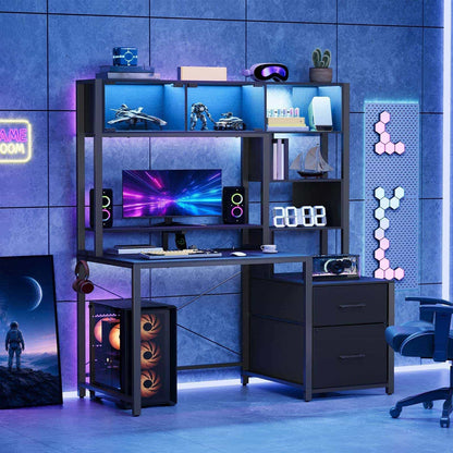 Immersive gaming room setup showcasing the black gaming desk glowing with colorful cool-toned neon LED lights at night.
