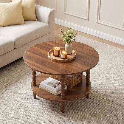 Rustic brown round coffee table styled on a rug next to a white couch with candles and flowers.