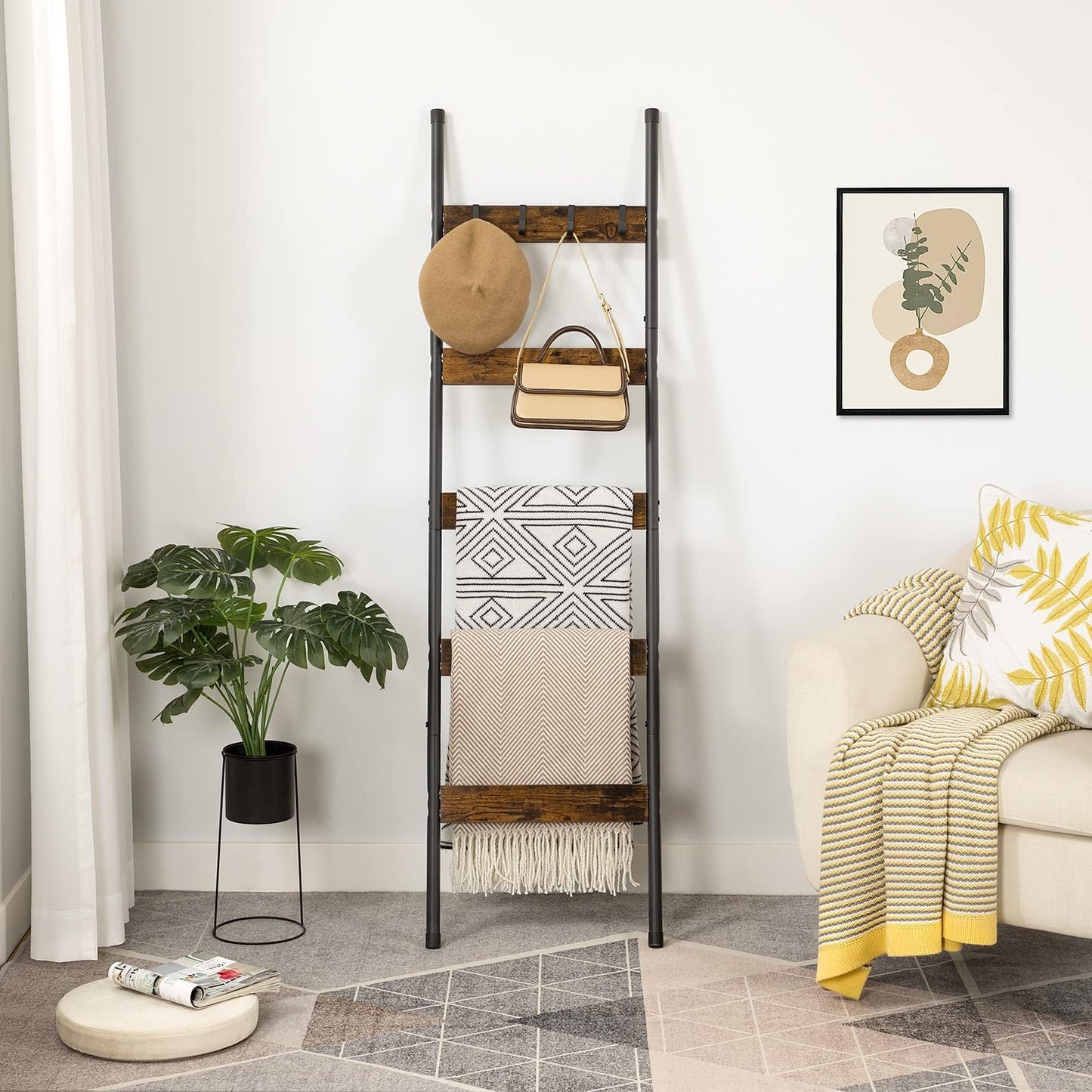 Rustic brown blanket ladder shelf leaning against a living room wall holding throws, a hat, and a handbag.