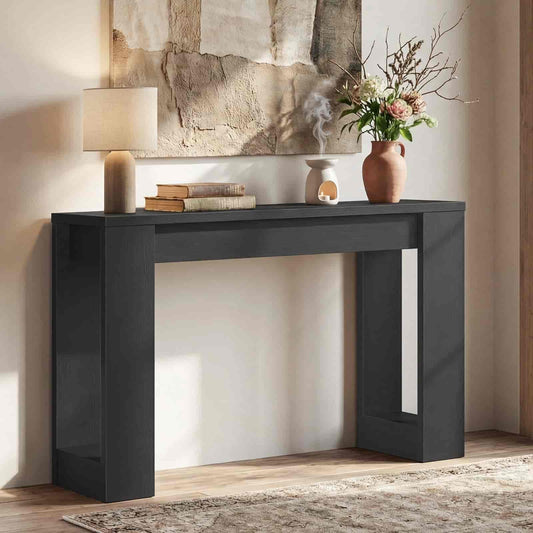 Modern black console table with decorative items against a neutral wall.