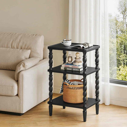 Black three-tier side table with decorative items in a living room setting.