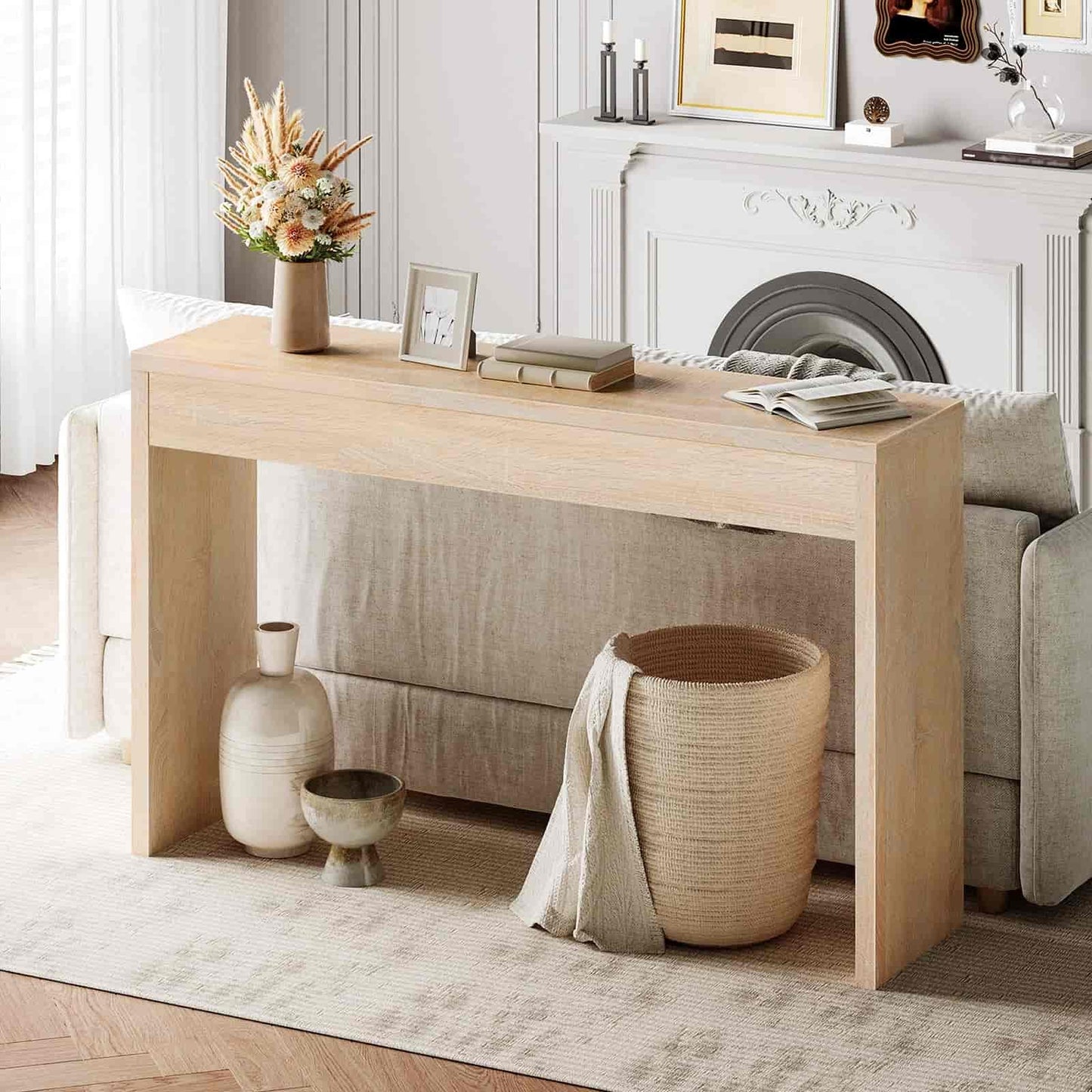 Light wood console table in a living room setting with decor items.