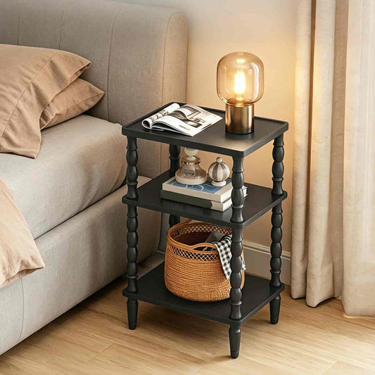 Black three-tier side table with decorative items next to a beige sofa.