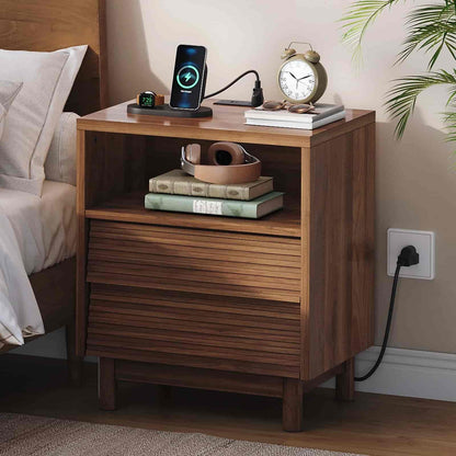 Wooden nightstand with electronic devices and books in a bedroom setting