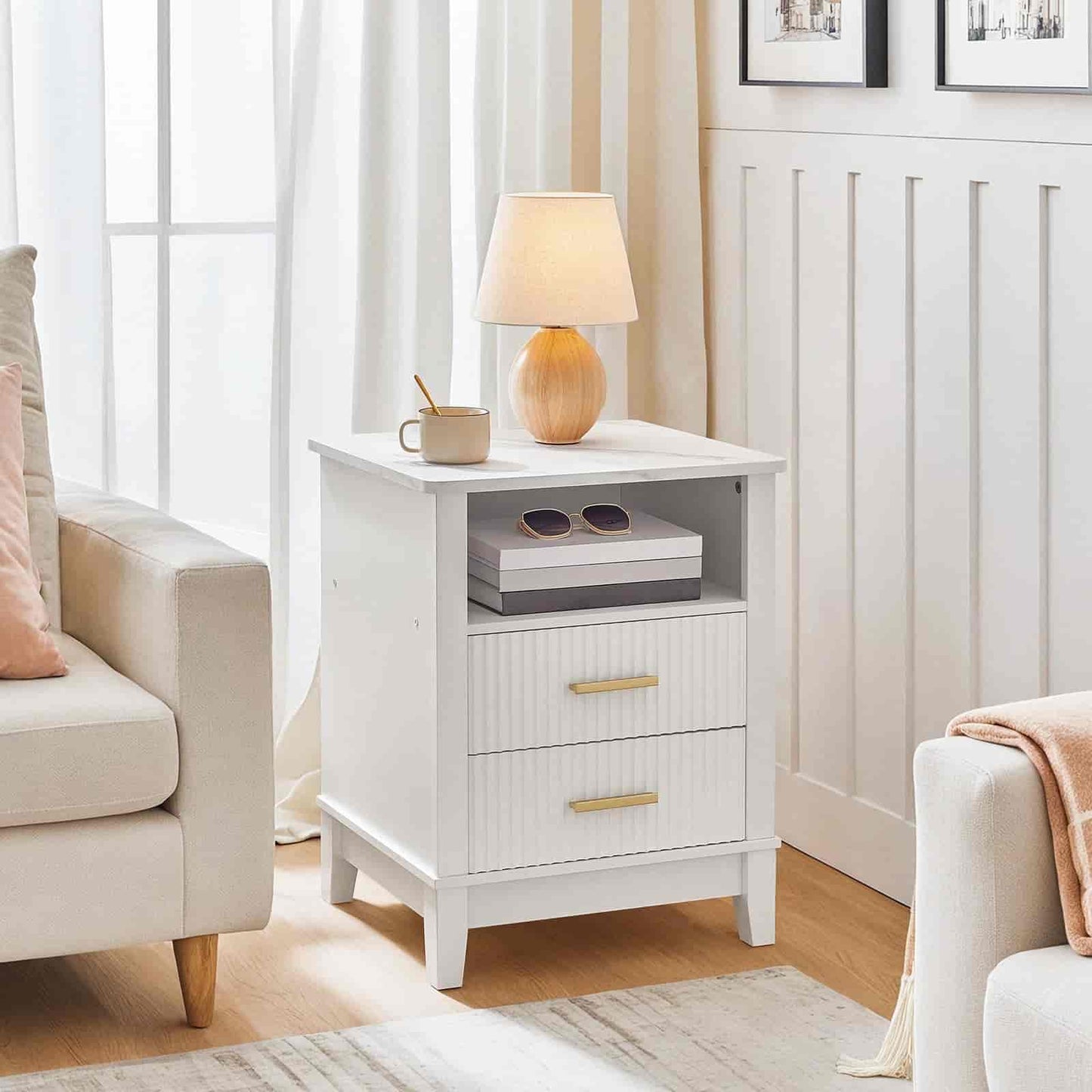 White nightstand with a lamp and books in a living room setting