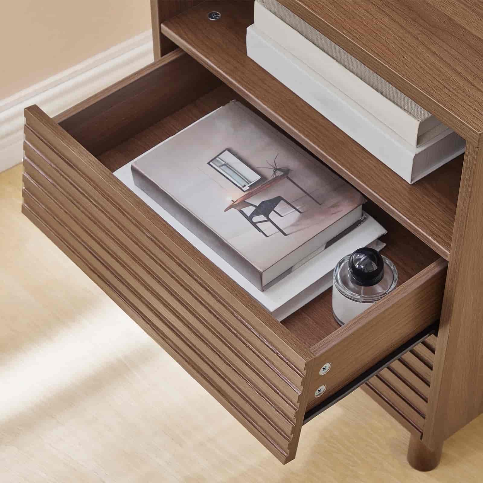 Wooden shelf with an open drawer containing books and a water bottle on a light wooden floor.