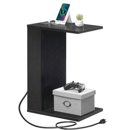Black side table with charging station and electronic devices on a white background