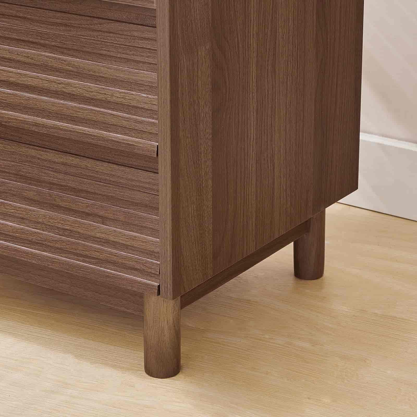 Wooden cabinet with a focus on the base and side panel on a wooden floor.