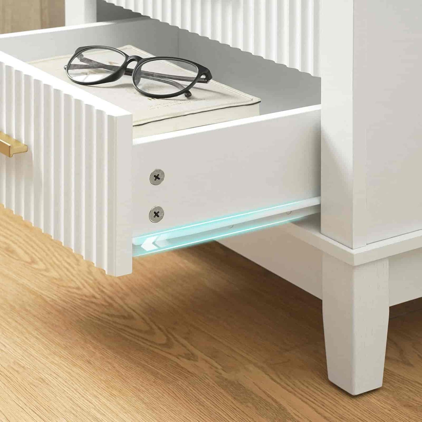 White nightstand with a glass shelf and book, featuring a pair of glasses on top.