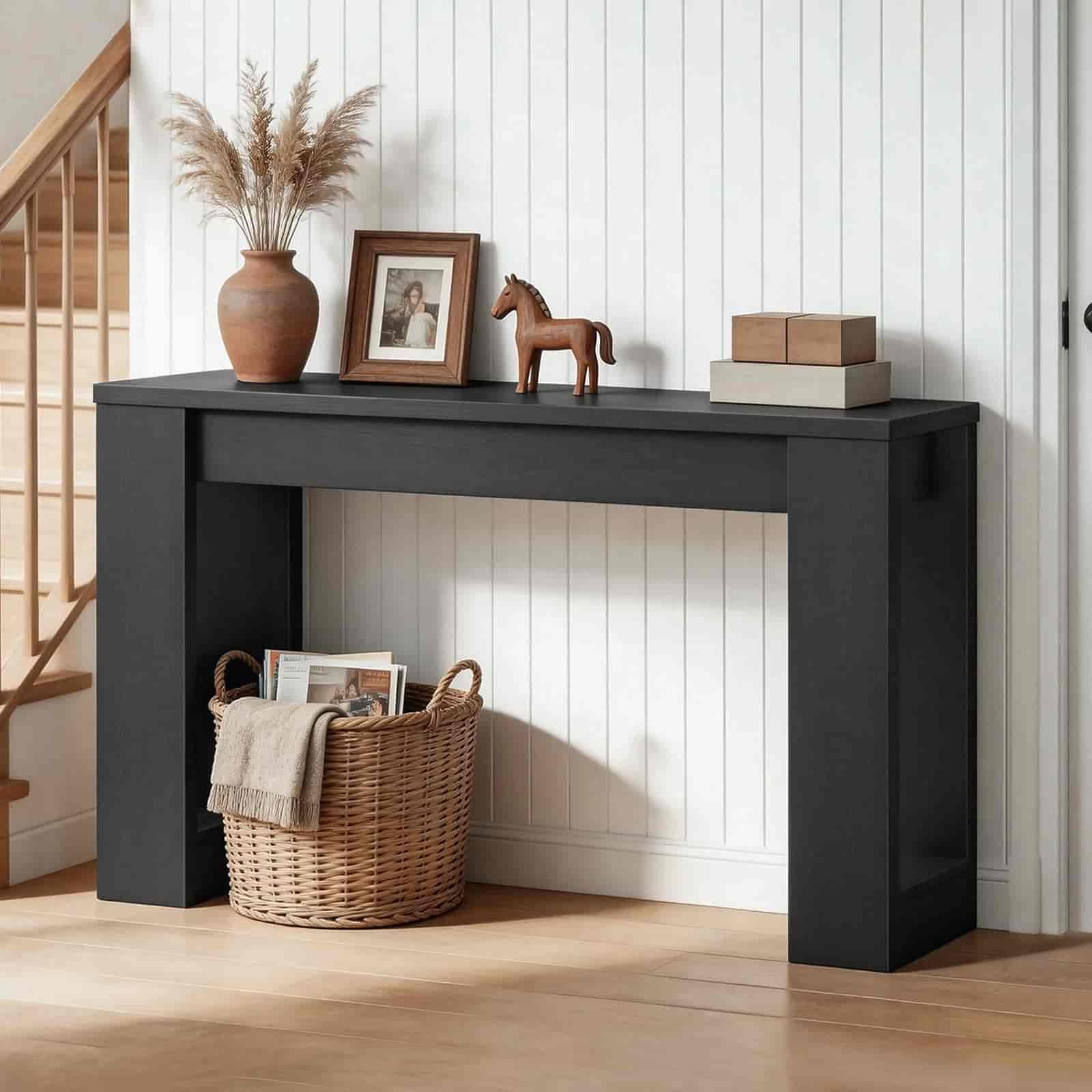 Black console table with decorative items against a white paneled wall.