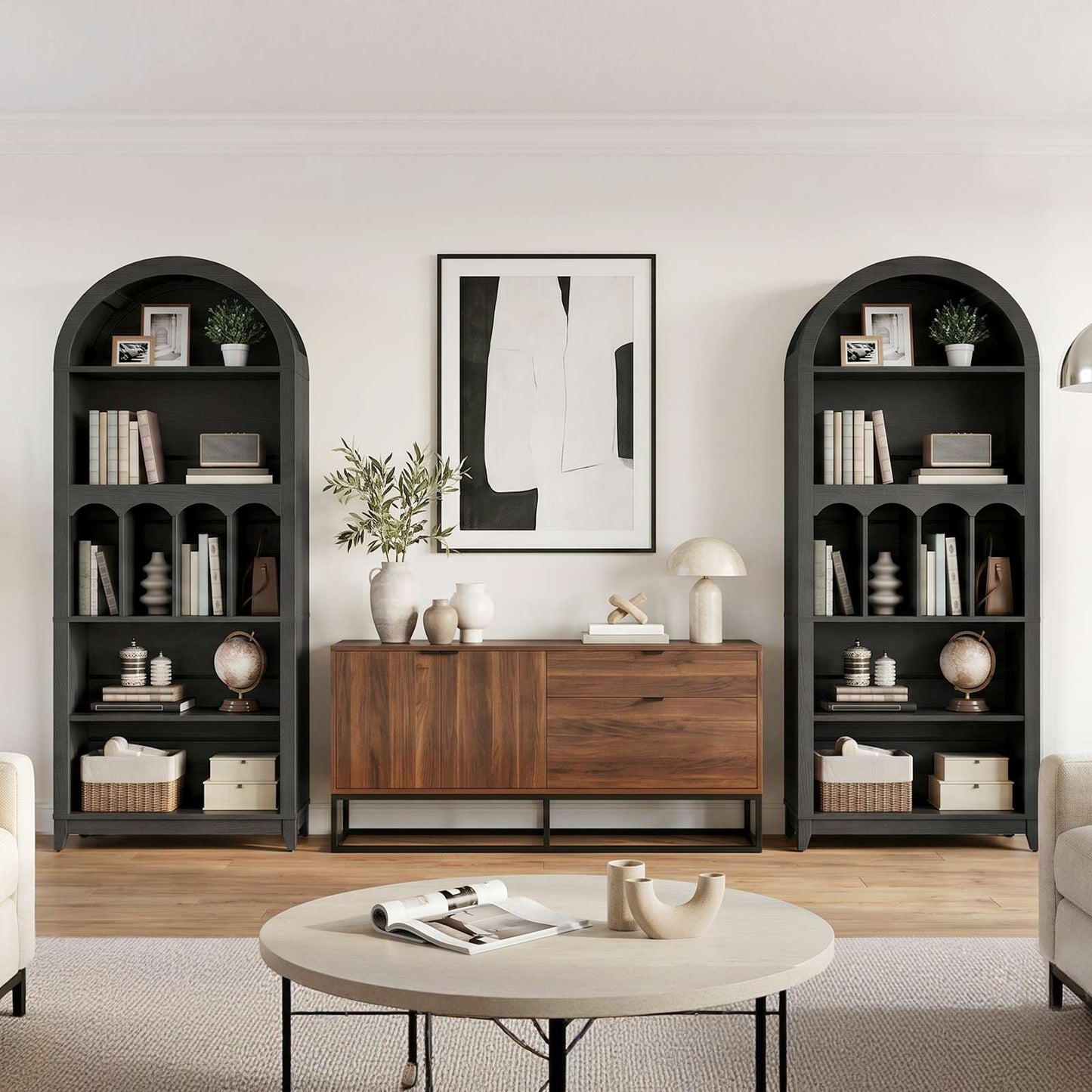 Modern living room setup with a matching pair of tall black arched bookshelves symmetrically framing a large credenza and wall art.
