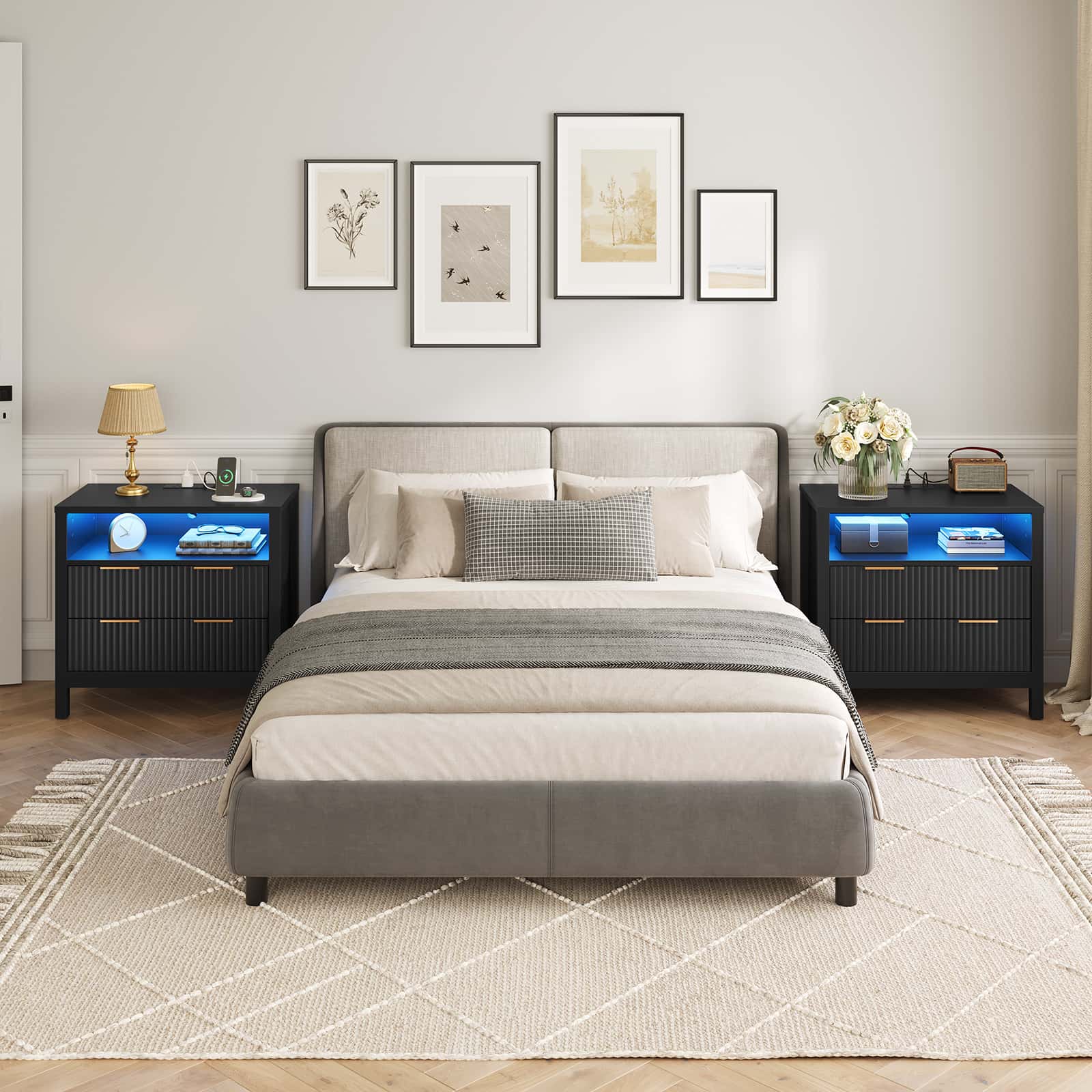 Modern bedroom with a gray upholstered bed, nightstands with LED lighting, and framed artwork on the wall.