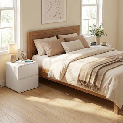 Neatly made bed with wooden headboard in a bright bedroom.