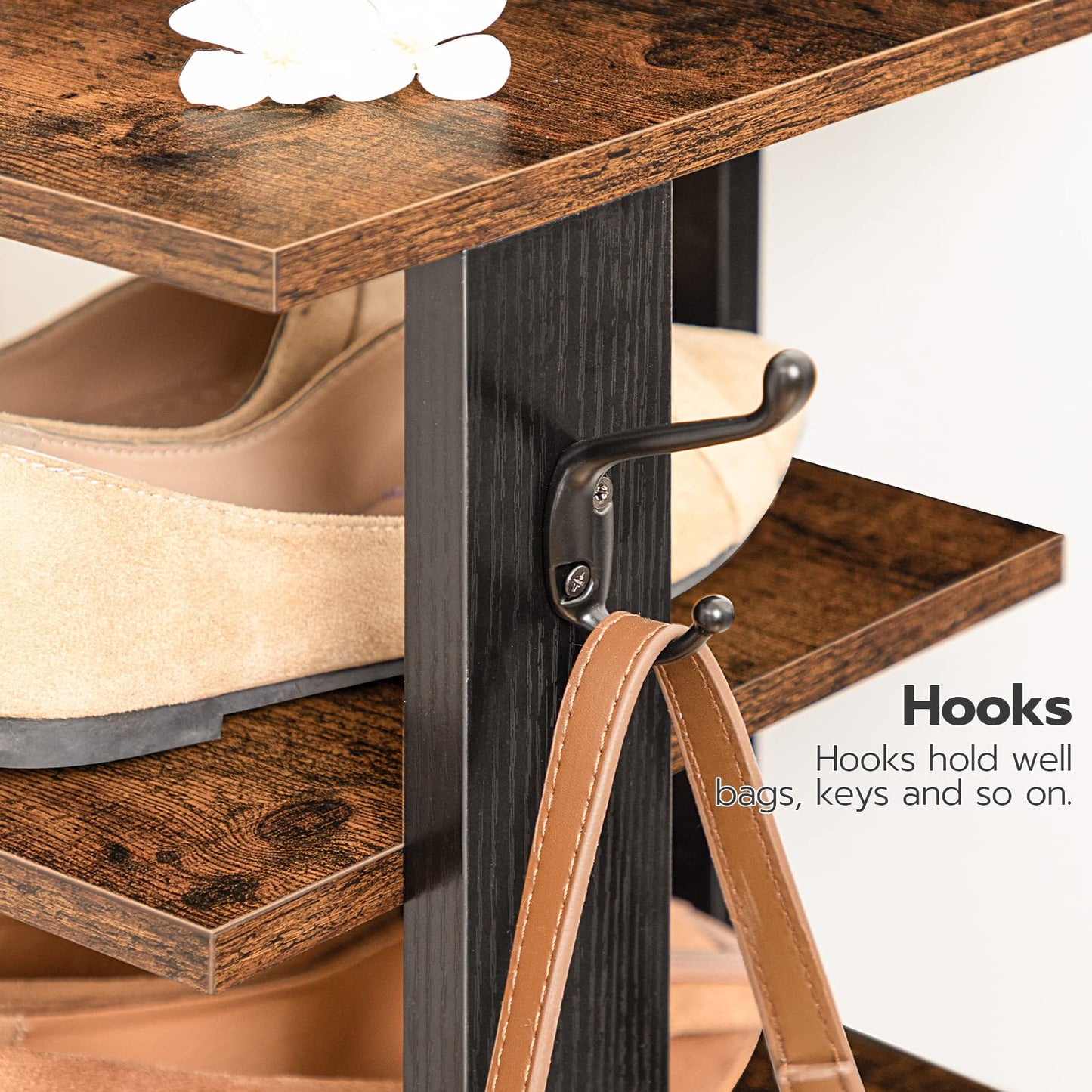 Close-up of durable metal side hanging hooks on the shoe tower holding a leather handbag.