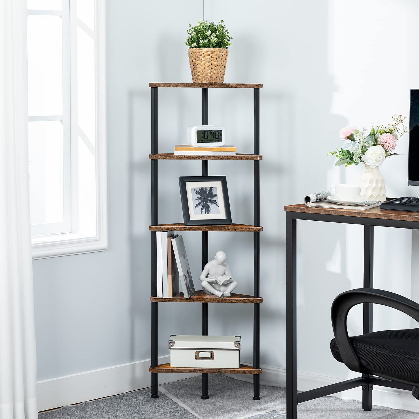 Skinny corner bookcase standing neatly next to a computer desk in a home office.