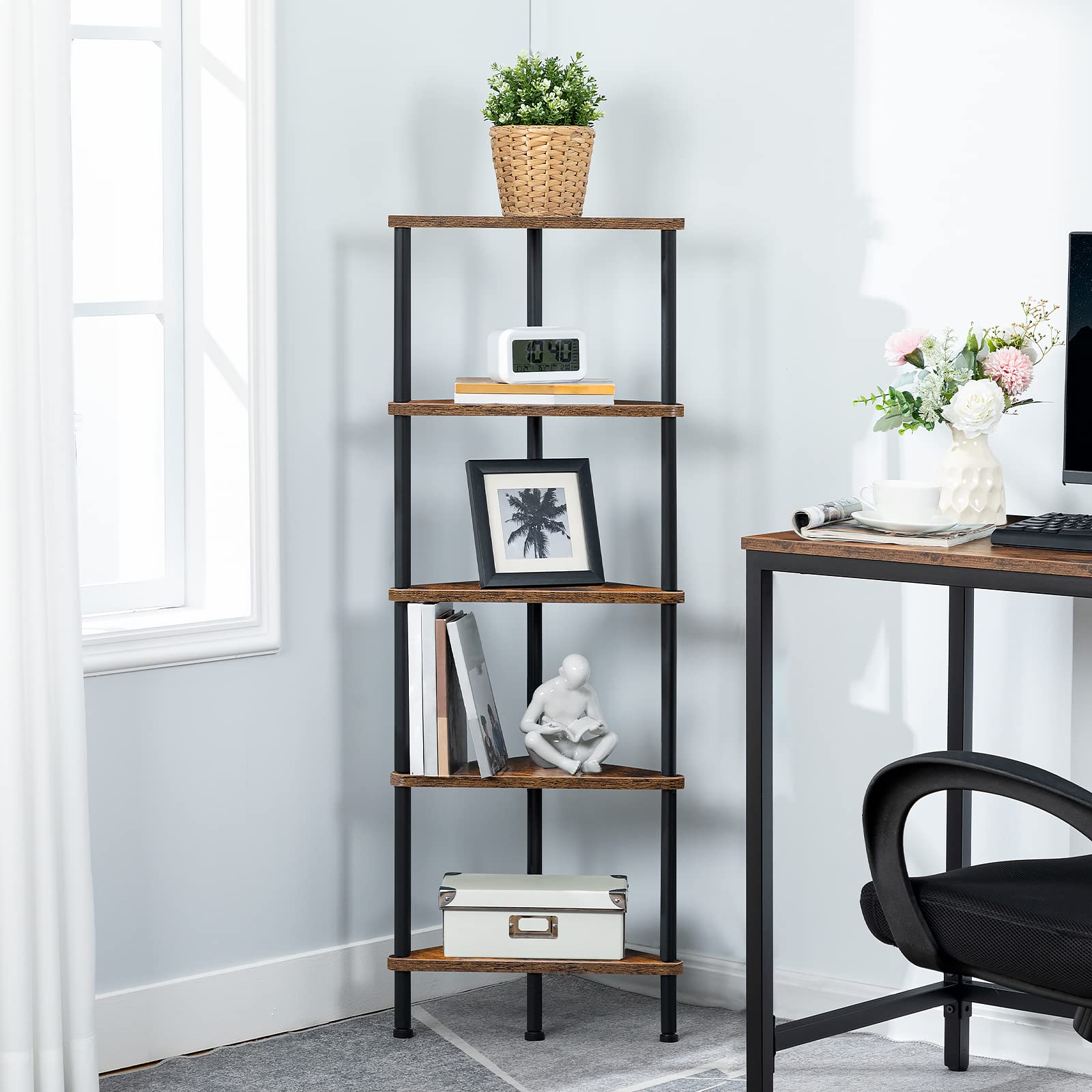 Skinny corner bookcase standing neatly next to a computer desk in a home office.