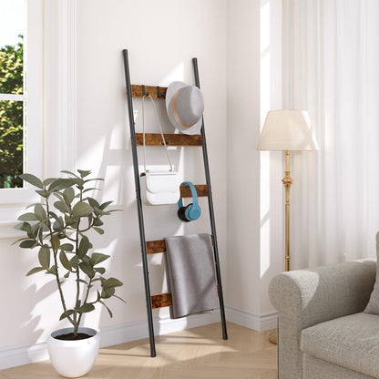 Skinny quilt holder rack tucked neatly into a small living room corner next to a floor lamp.