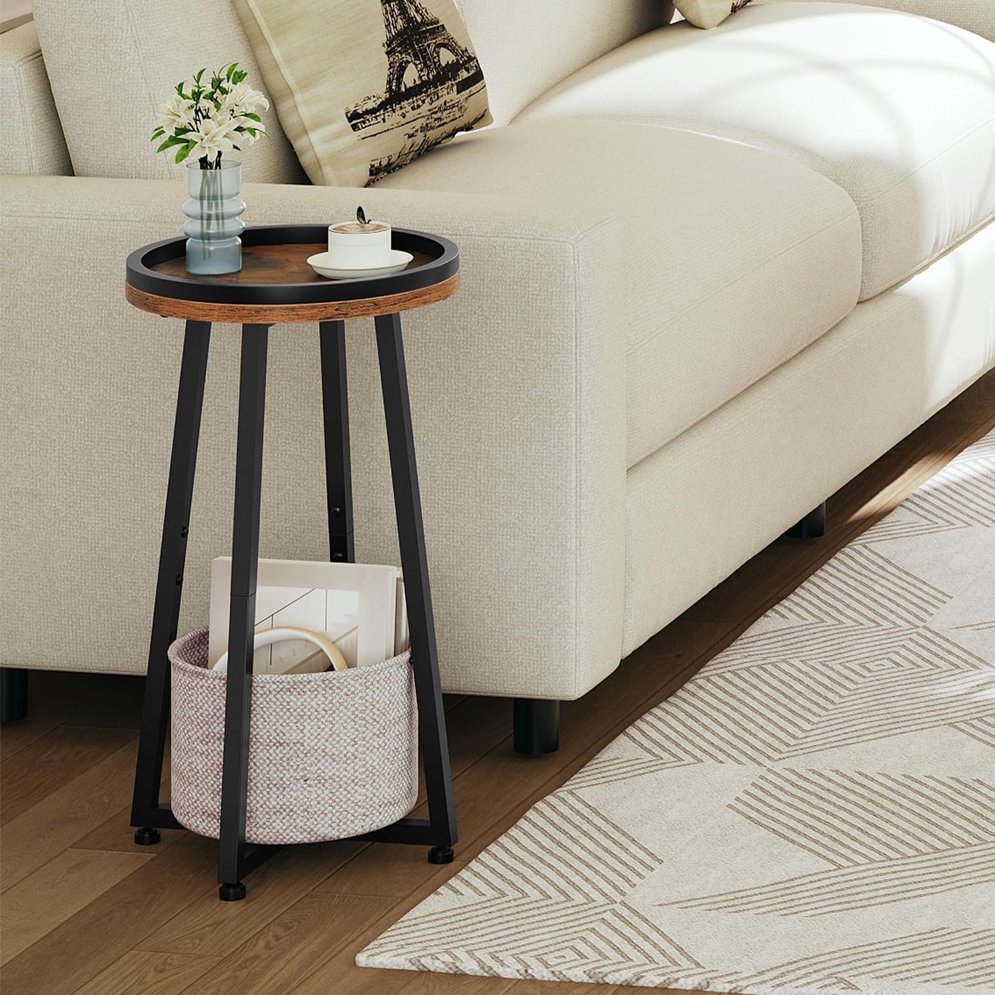 Skinny round sofa side table holding a ceramic tea mug placed next to a modern cream white fabric couch.
