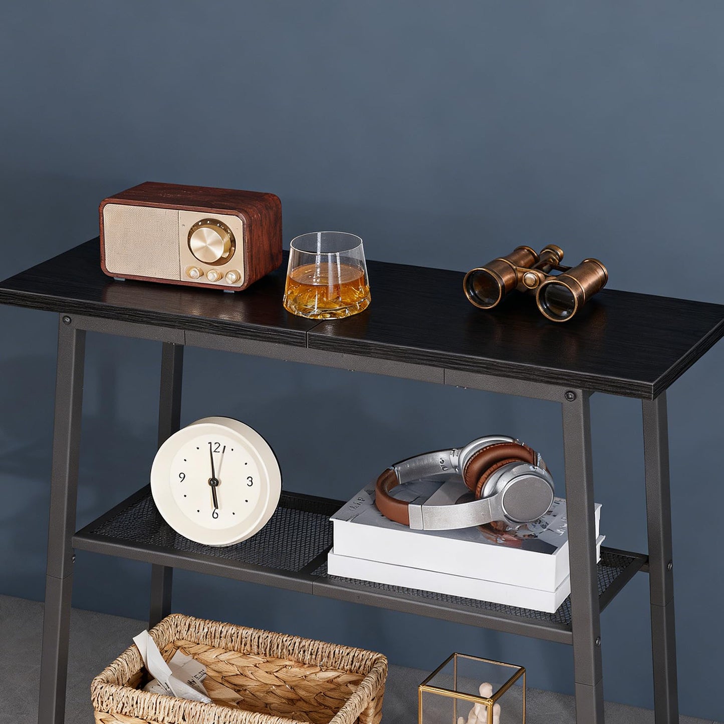 Close up of the sleek black accent display shelf holding a whiskey glass and a retro radio against a dark blue wall.