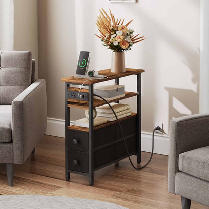  Industrial narrow end table with charging station and a vase of flowers placed between two grey armchairs