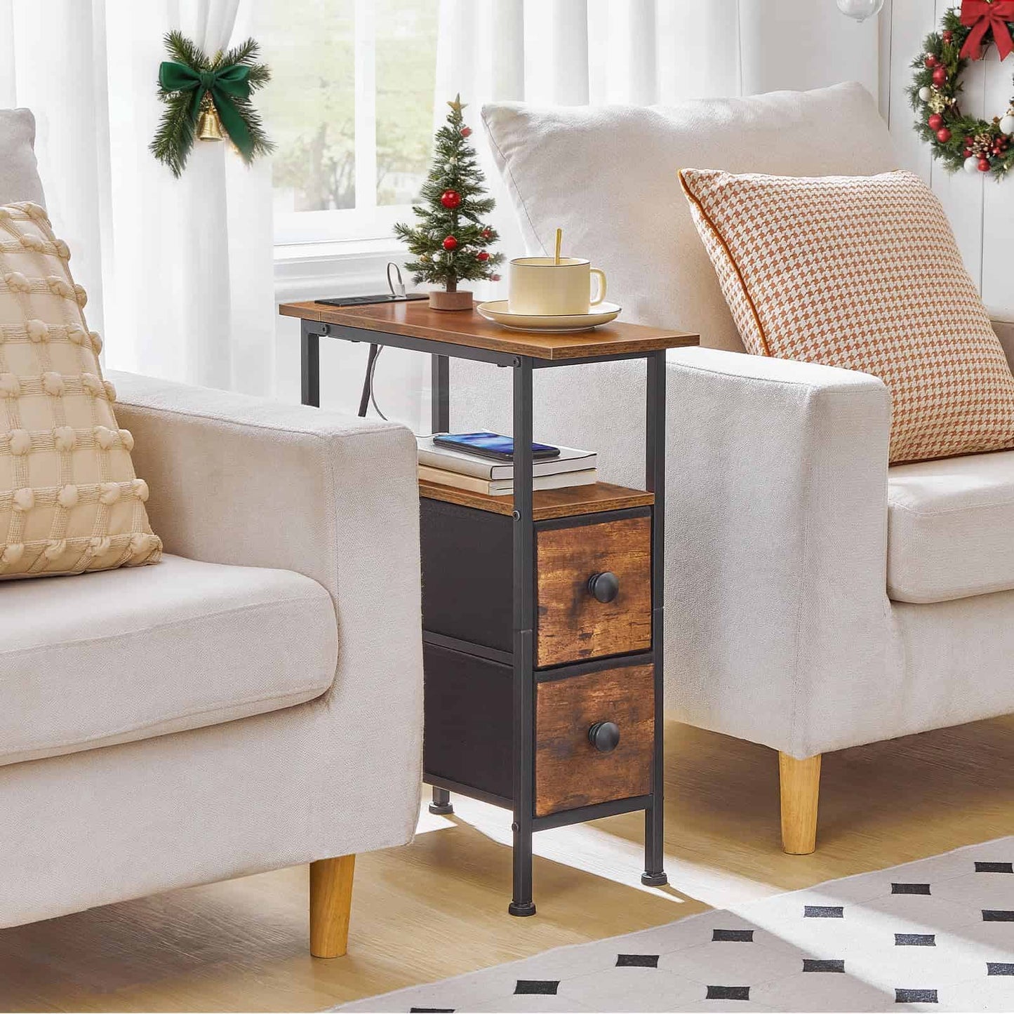 Industrial narrow end table with charging station and a vase of flowers placed between two grey armchairs.
