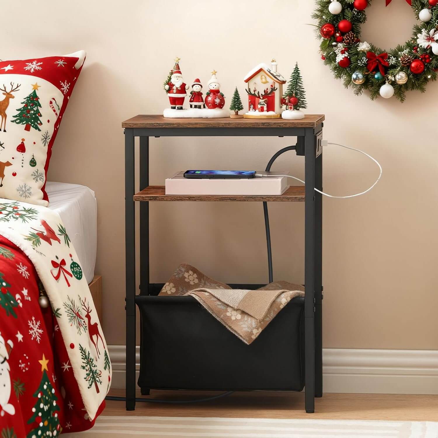 Nighstand with Christmas decor next to a bed with festive bedding.