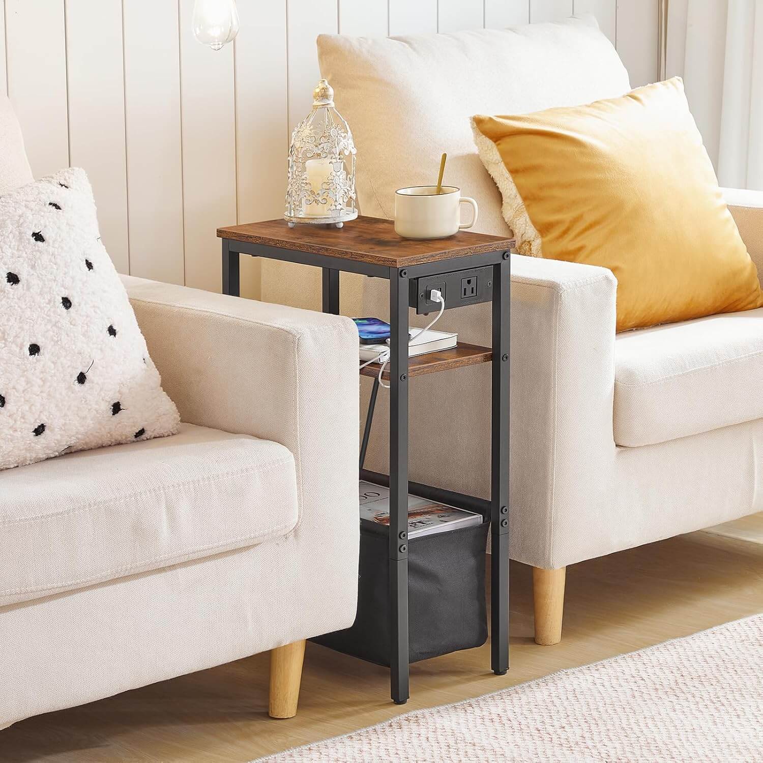 Small wooden side table with black metal legs next to a white sofa with yellow and patterned cushions.