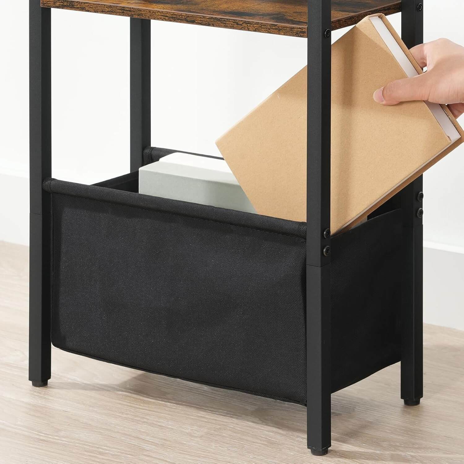 Black storage unit with a wooden top, holding books and a notebook.