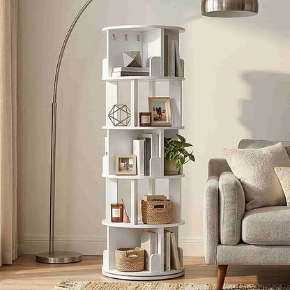 White lazy susan style revolving bookcase placed in the corner of a living room next to a grey sofa.