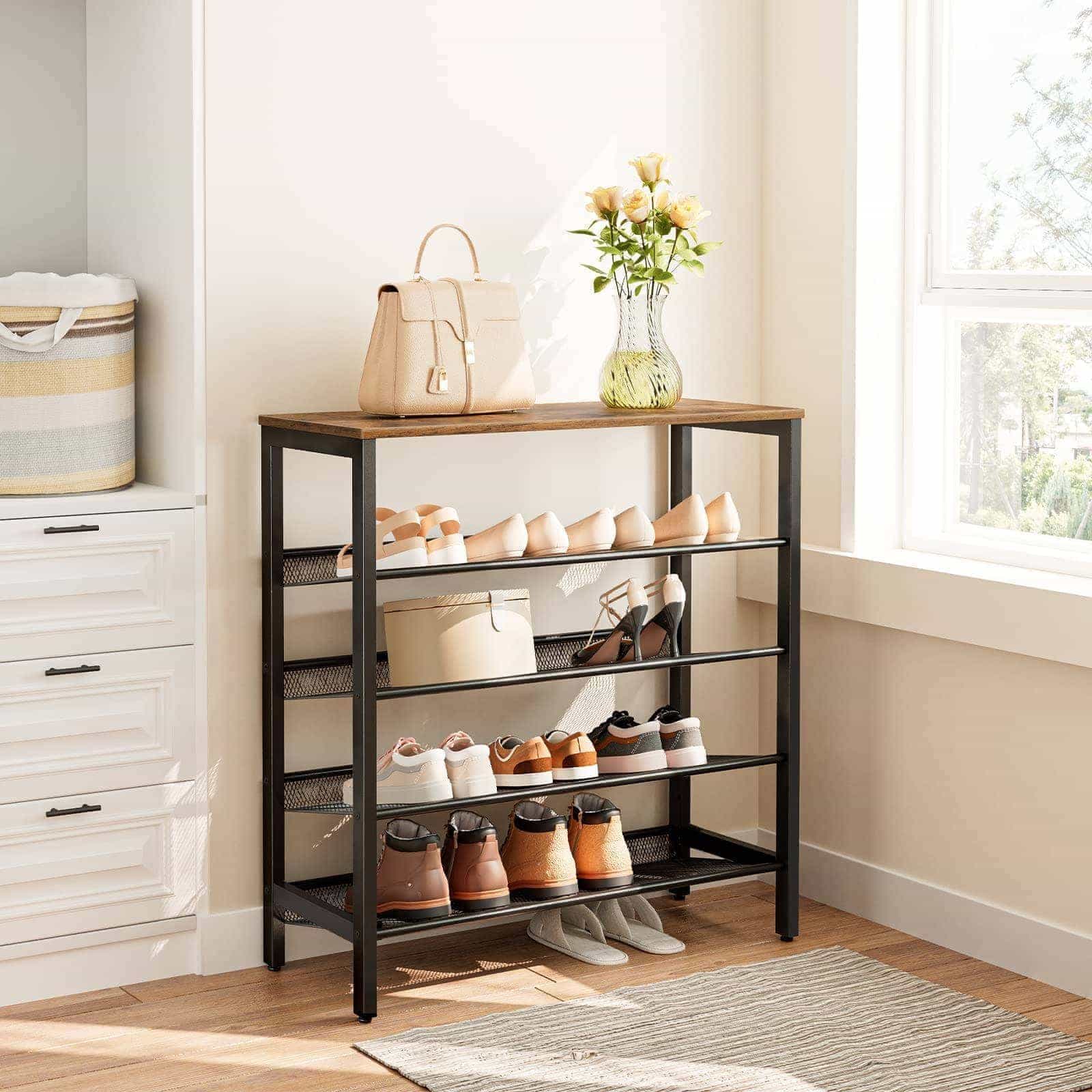Shoe rack with shoes, a bag, and a vase of flowers in a room with a window and drawers.