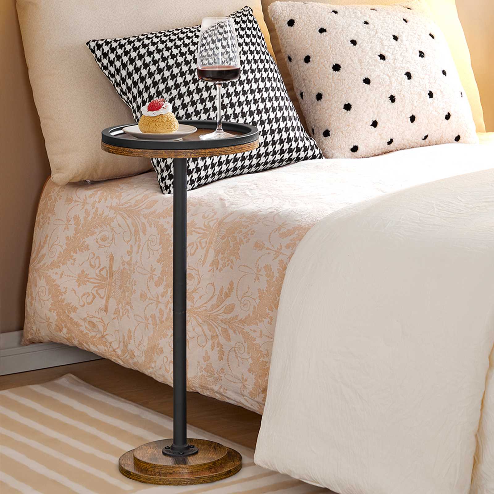 Space-saving tall round nightstand sliding right next to a bed holding candles in a bedroom.