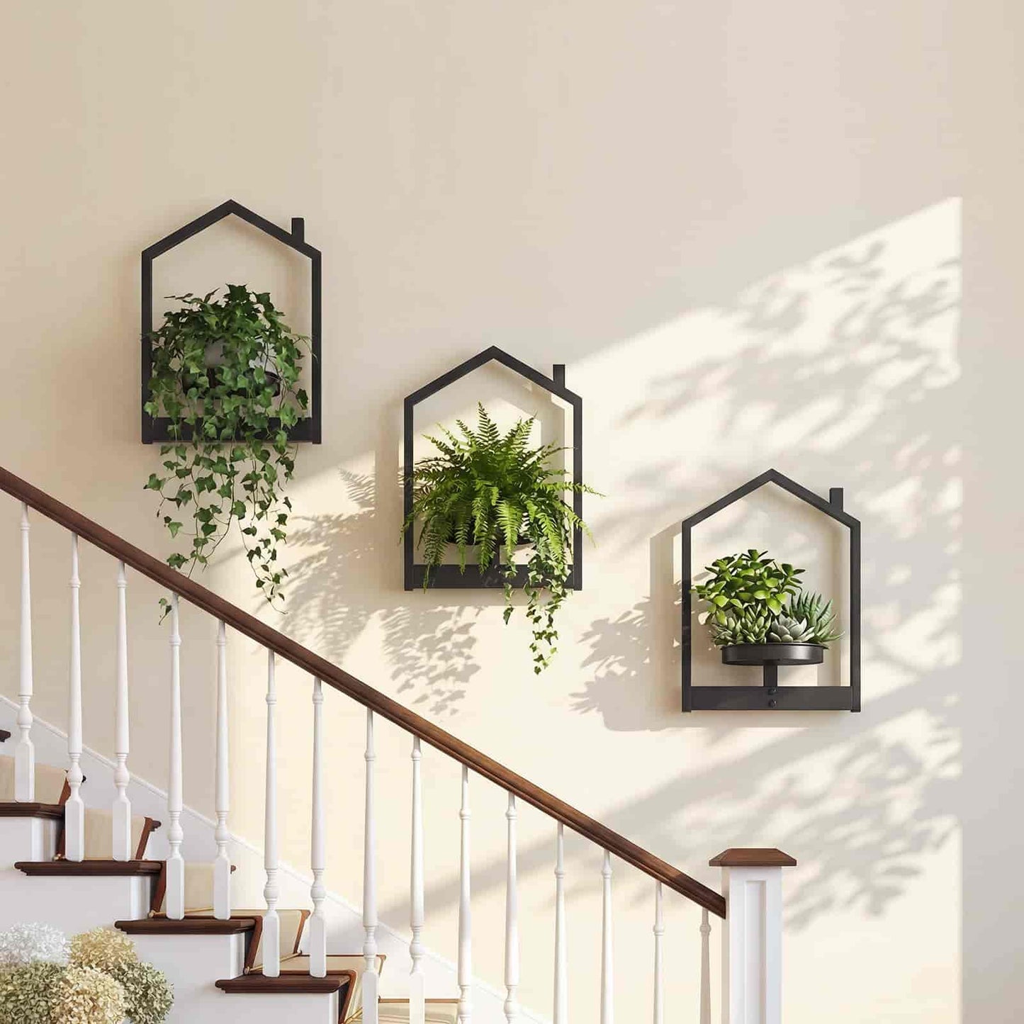Diagonal cascading layout of three house-shaped hanging plant holders along a modern wooden staircase wall.