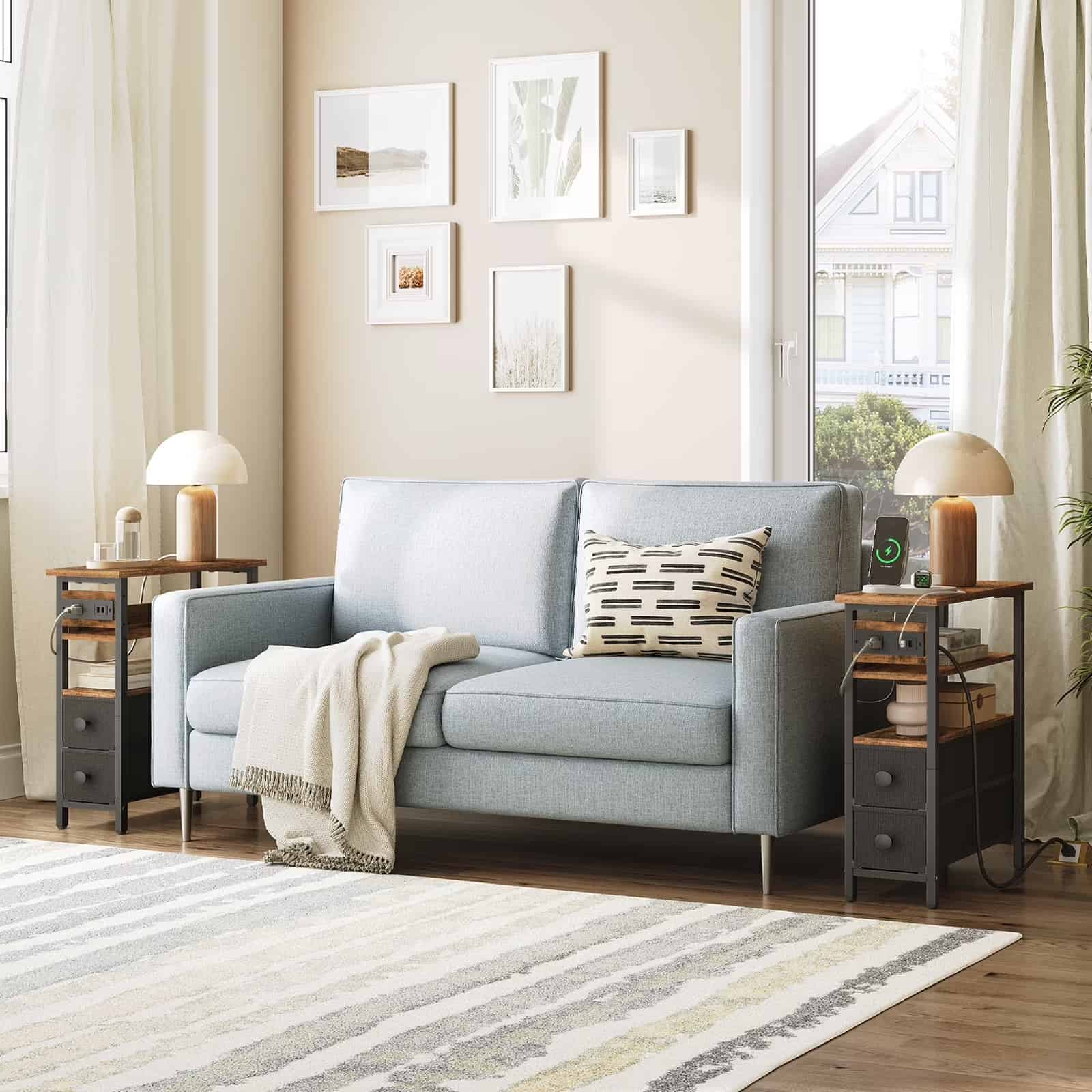  Symmetrical modern living room arrangement with two slim industrial end tables framing a grey fabric sofa.