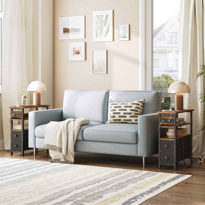  Symmetrical modern living room arrangement with two slim industrial end tables framing a grey fabric sofa.