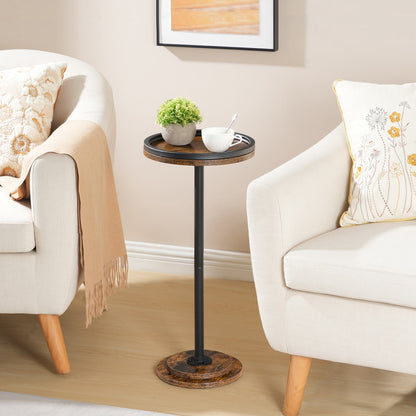 Rustic brown tall round side table with a tray top styled between two white living room armchairs.