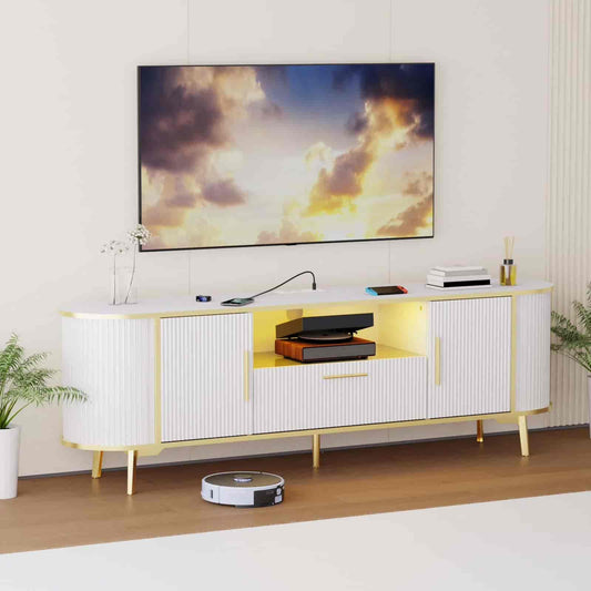 White entertainment console with gold accents in a living room setting, featuring a TV displaying a sunset.