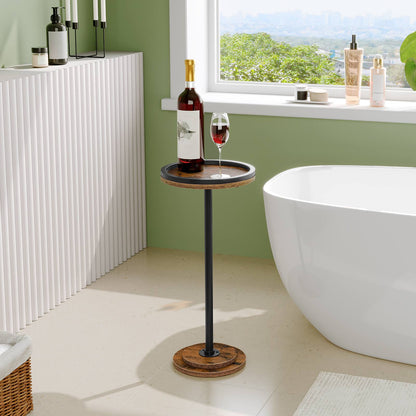 Water-resistant round side table placed by a window next to a bathtub holding a wine bottle and glass.
