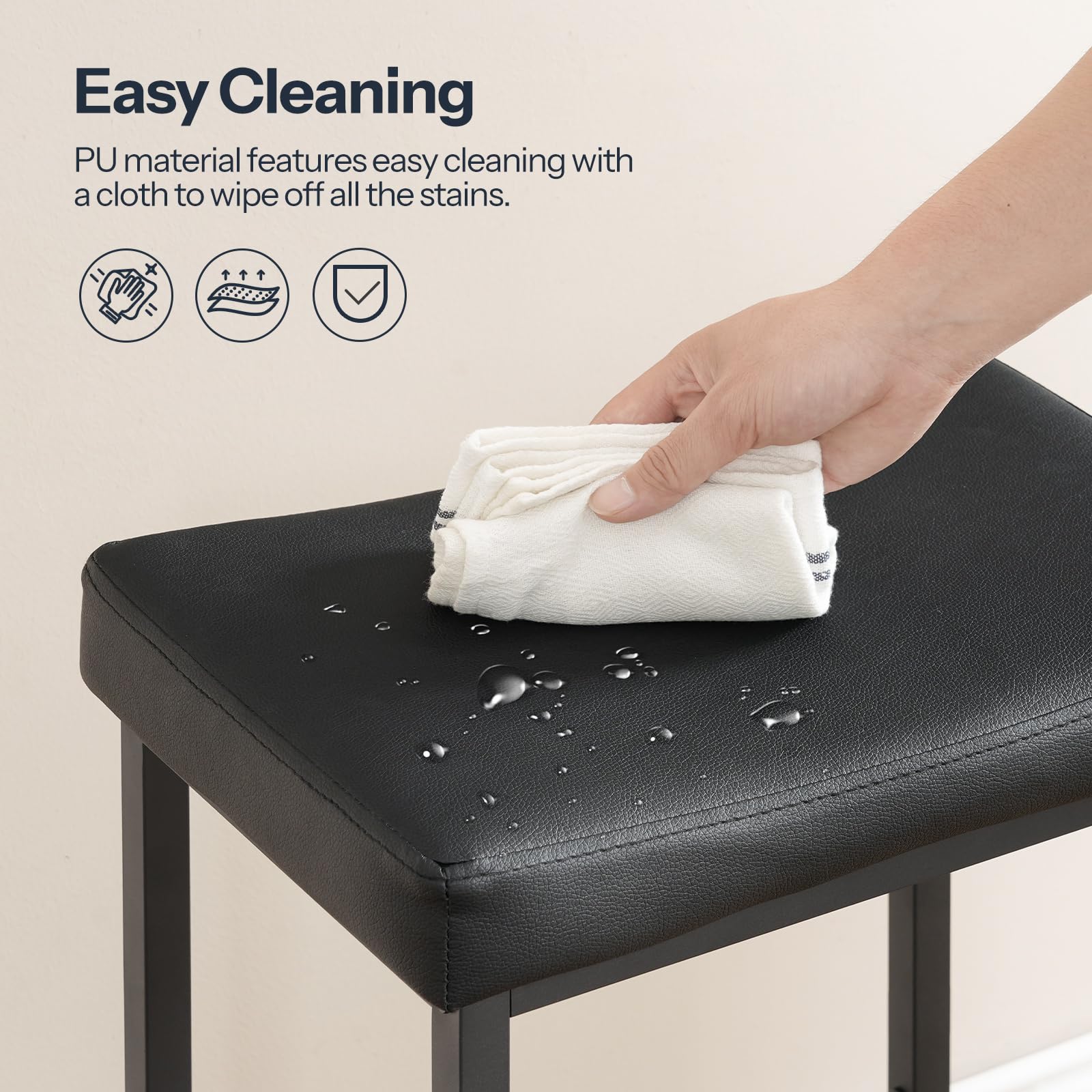 A hand wiping water droplets off the waterproof black PU leather barstool seat for easy cleaning.