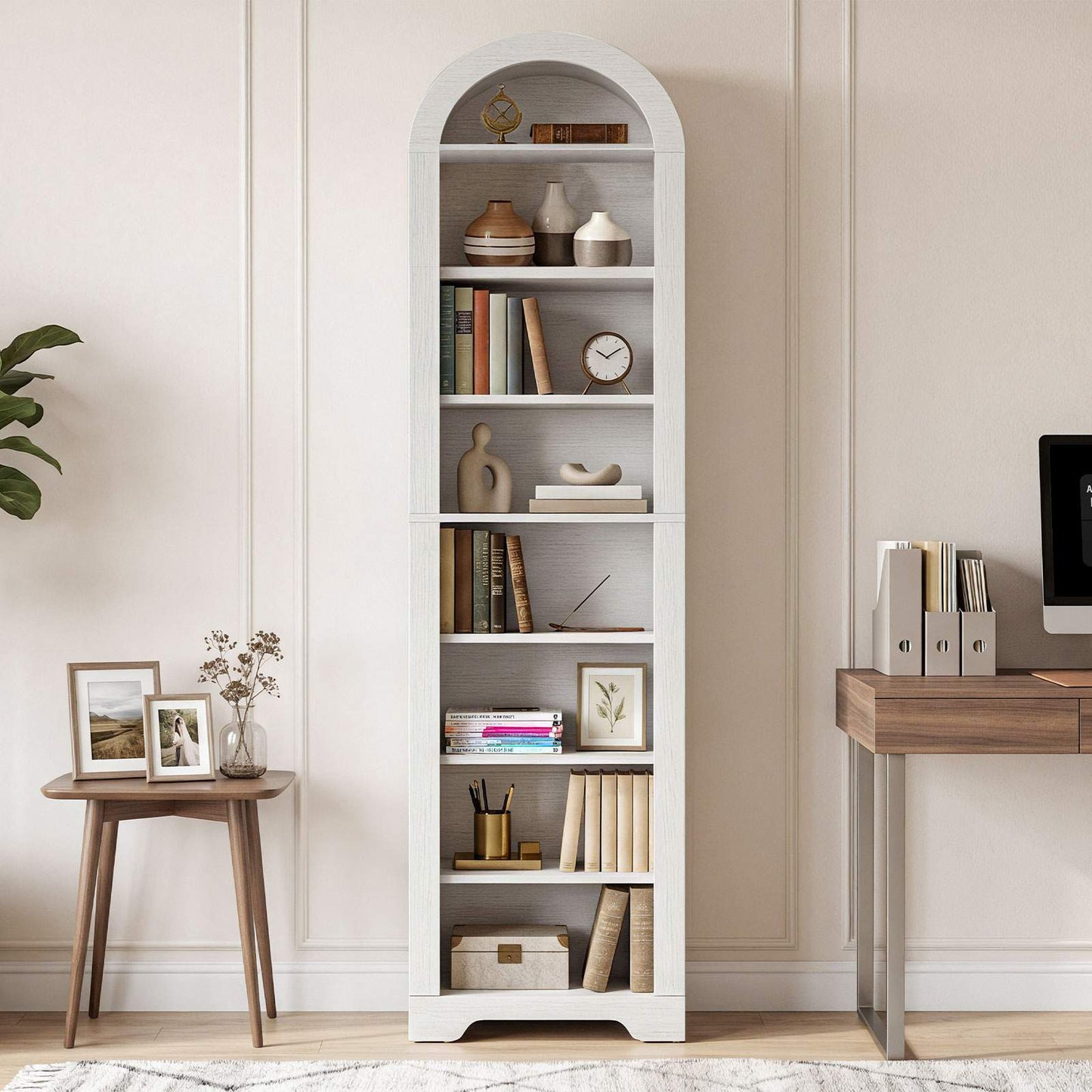 White arched tall bookshelf with open shelves holding books and decor in a modern home office.