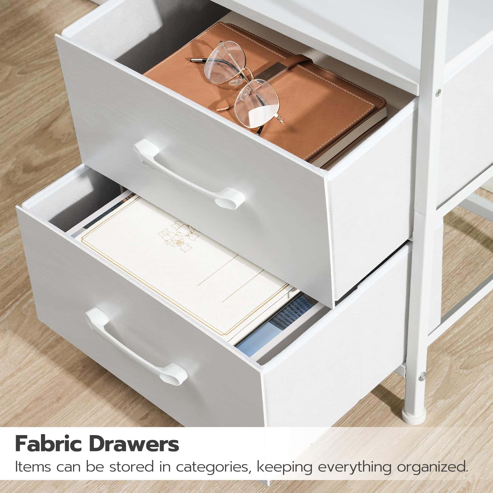 White storage unit with fabric drawers containing sunglasses and a notebook on a wooden floor.