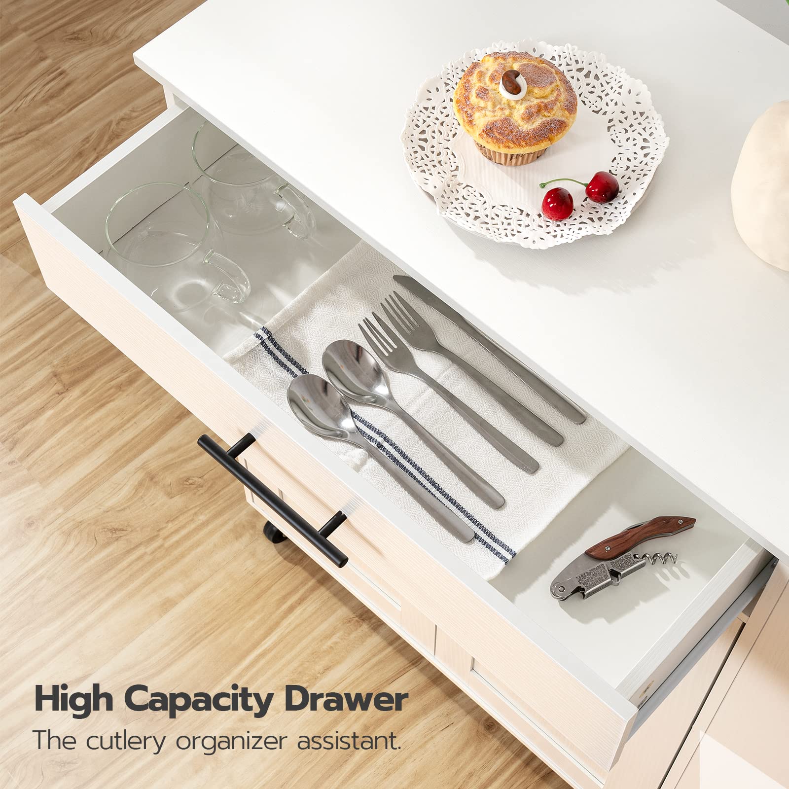 Open kitchen drawer with cutlery organizer and a cupcake on a wooden surface