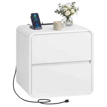 White nightstand with a phone, mug, and flowers on top